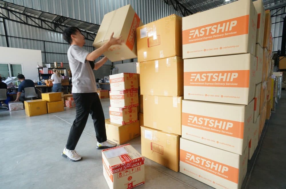 ทีมงาน FastShip ยกกล่องพัสดุขึ้นกองที่คลังสินค้า