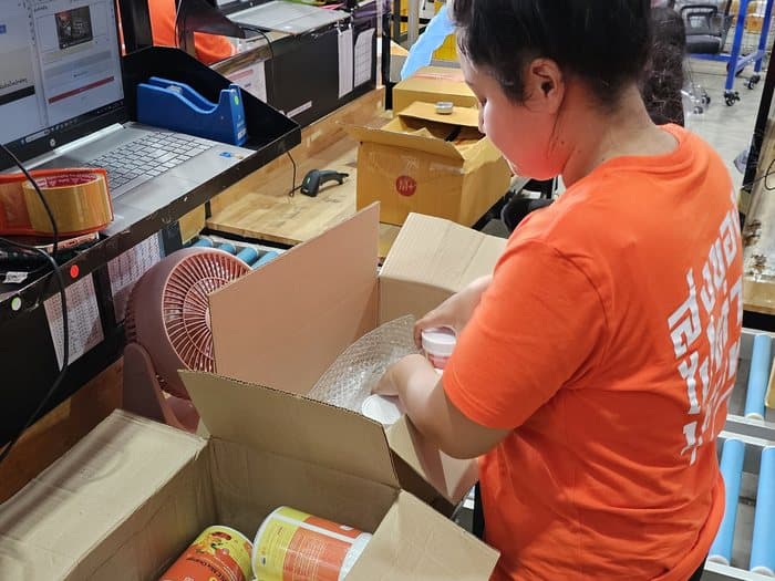 ทีมงาน FastShip กำลังแพ็กสินค้าลงกล่องอย่างเรียบร้อยก่อนส่งจริง
