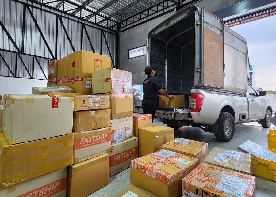 ทีมงาน FastShip กำลังจัดเรียงและขนพัสดุขึ้นรถส่งจริงที่คลังสินค้า